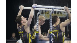 Hawkeye members Jake Brodarzon, Nick Merryman, and Dylan Ellsworth put chalk on the parallel bars before they compete during mens gymnastics Iowa vs. Penn State and Arizona State on March 3, 2018 at Carver Hawkeye Arena.