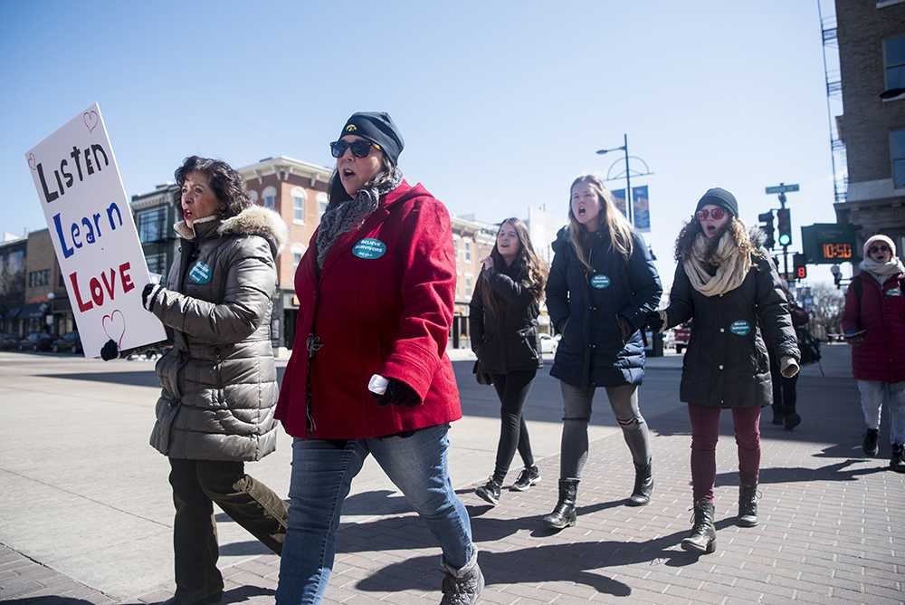 Protestors march on Washington St. for the Iowa City March Against Rape Culture on Saturday, April 7, 2018. In solidarity with The National March Against Rape Culture in Washington, D.C., community members wrote postcards to political representatives and expressed support to others to fight the stigma of American rape culture. (The Daily Iowan/Olivia Sun)