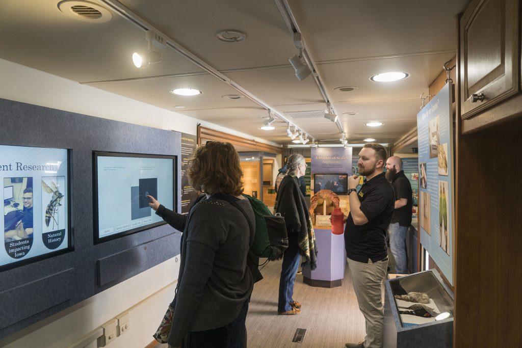 One of the staff is watching visitor to operate the touch screen in the UI Mobile Museum on the plaza between the Main Library and the Adler Journalism Building on Wednesday, April 11, 2018. (The Daily Iowan/ Gaoyuan Pan)