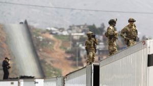 Military Police keep watch near the Mexico border as President Donald Trump takes a tour of the border wall prototypes near the Otay Mesa Port of Entry in San Diego County, Calif., on March 13, 2018. (K.C. Alfred/San Diego Union-Tribune/TNS)