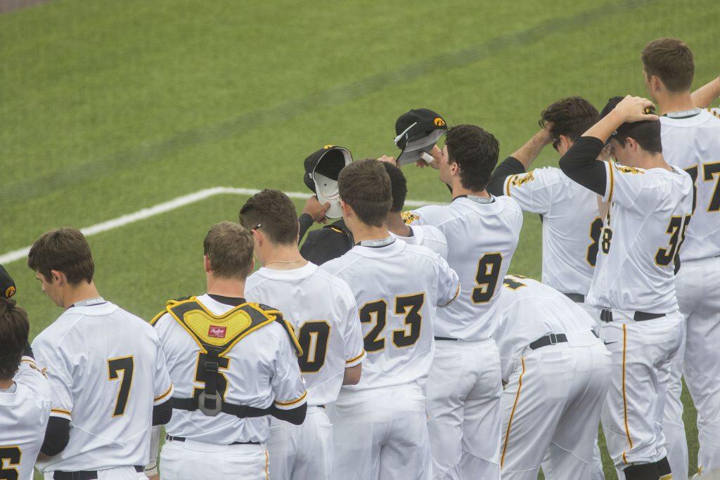 Iowa players replace their caps after the national anthem during the Iowa/Mizzou baseball game at Duane Banks Field on Tuesday, May 1, 2018. The Tigers defeated the Hawkeyes, 17-16, with two extra innings. (Lily Smith/The Daily Iowan)