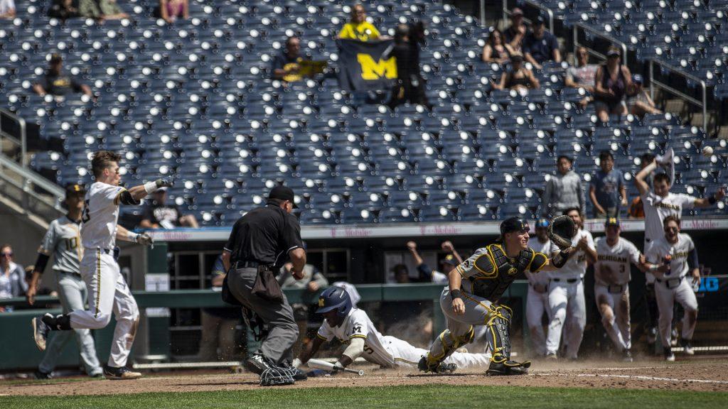 Michigans Christian Bullock slides into home on a sac fly in to win the game during Iowas Big Ten tournament Game against Michigan at TD Ameritrade Park in Omaha, Neb. on Wed. May 23, 2018. The Wolverines defeated the Hawkeyes 2-1 in extra innings. (Nick Rohlman/The Daily Iowan)