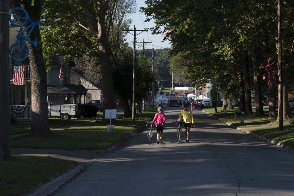 Riders walk their bikes up a hill in Wellman, Iowa during RAGBRAI on Friday, July 27, 2018. Riders rode from Sigourney to Iowa City on Day 6 of this years ride. (Nick Rohlman/The Daily Iowan)