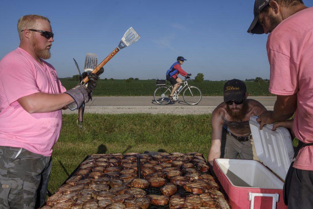 Mr. Pork Chop Employees cook pork outside of Wellman, Iowa during RAGBRAI on Friday, July 27, 2018. Riders rode from Sigourney to Iowa City on Day 6 of this years ride. (Nick Rohlman/The Daily Iowan)