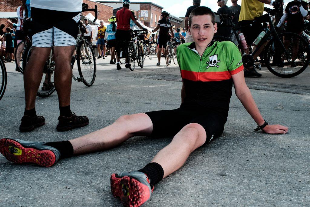 Gavin Drucker, 15, of Madison, Wisconsin is seen relaxing in Kalona, Iowa on the sixth day of RAGBRAI, on Friday, July 27th, 2018. This is Gavins twelth year riding. I started out in my dads Burley. Then we moved to a tagalong. Then I got my first road bike, he explained. Riders rode from Sigourney to Iowa City on Day 6 of this years ride. (Jared Krauss/The Daily Iowan)