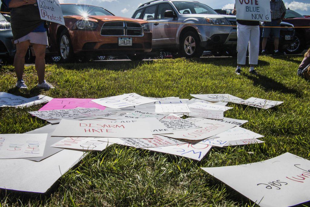 Posters are seen on the ground outside of Northeast Iowa Community College in Peosta on July 26, 2018. Both pro- and anti-Trump demonstrators were present for the arrival of the president. (Katina Zentz/The Daily Iowan)