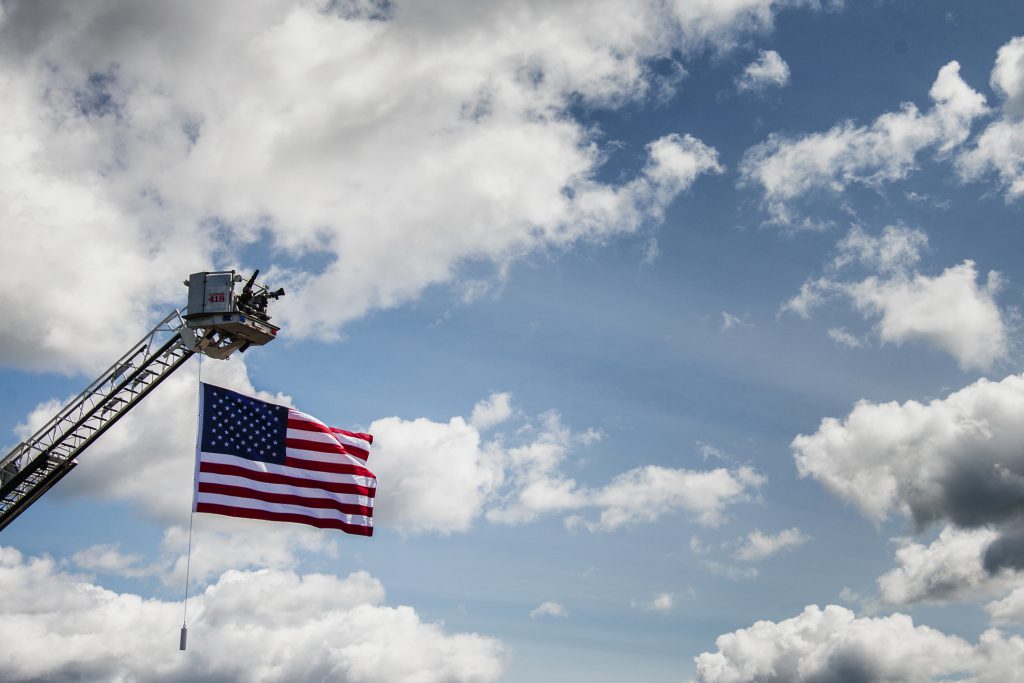 The American flag hangs in the air outside of Northeast Iowa Community College in Peosta on July 26, 2018. Both pro- and anti-Trump demonstrators were present for the arrival of the president. (Katina Zentz/The Daily Iowan)