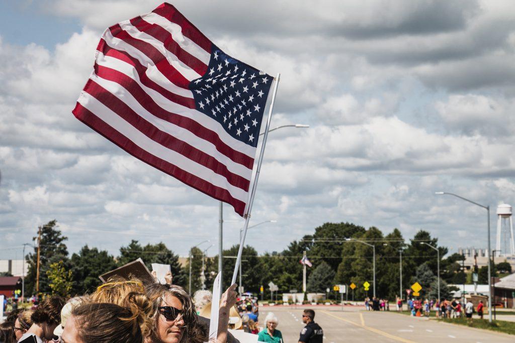 Attendees wave the American flag outside of Northeast Iowa Community College in Peosta on July 26, 2018. Both pro- and anti-Trump demonstrators were present for the arrival of the president. (Katina Zentz/The Daily Iowan)