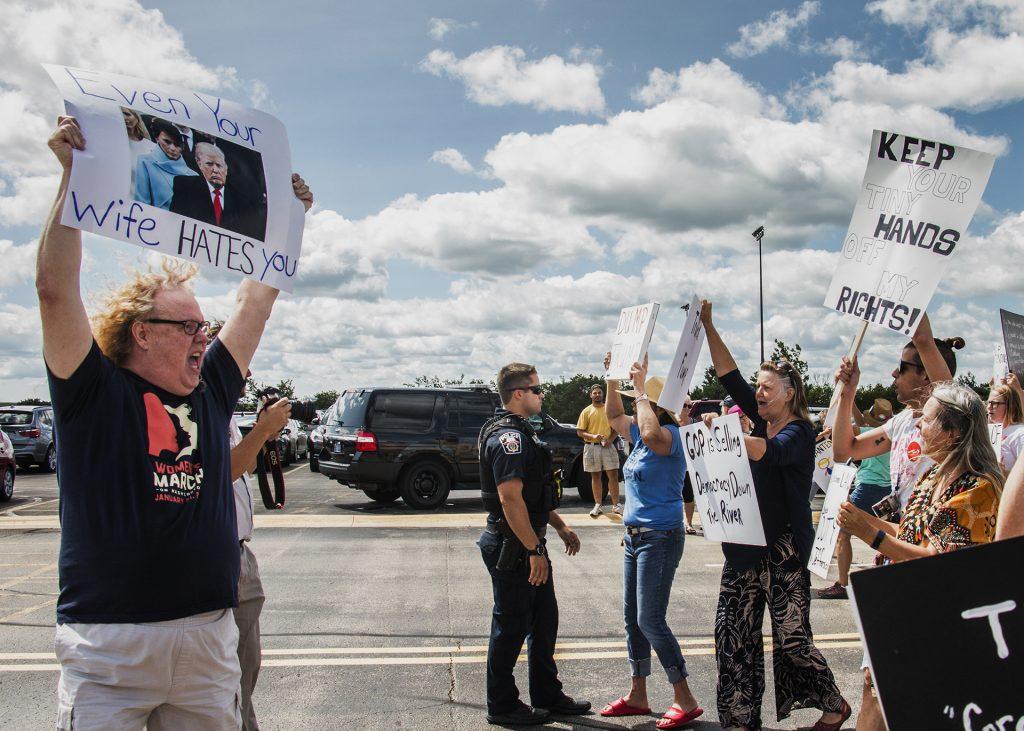 Attendees march toward Northeast Iowa Community College in Peosta on July 26, 2018. Both pro- and anti-Trump demonstrators were present for the arrival of the president. (Katina Zentz/The Daily Iowan)