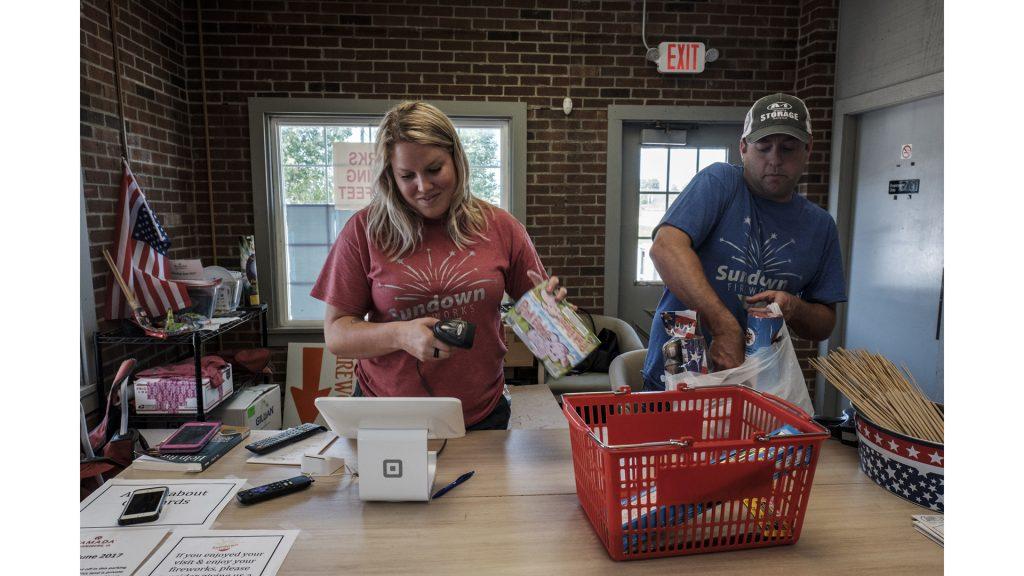 Sundown Fireworks employee Keeley Arnold and owner Travis Allen ring up a customer's purchase on Friday, June 29, 2018. In Iowa fireworks are only allowed to be sold seasonally. During the rest of the year Arnold works as a teacher and Allen runs a farm outside of Tiffin with his family. (Nick Rohlman/The Daily Iowan)