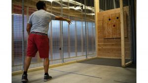 A customer throws a hatchet during the soft opening of Hatchet Jacks on Saturday, June 30, 2018. Hatchet Jacks will be opening soon and allows patrons to throw axes while enjoying beer and wine. (Matthew Finley/The Daily Iowan)