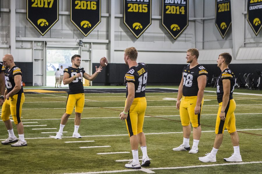 Iowa offensive players throw around a football in the University of Iowa Indoor Practice Facility during Iowa Football Media Day on Friday, August 10, 2018. Iowa will open the 2018 football season at home against Northern Illinois on Saturday, September 1.