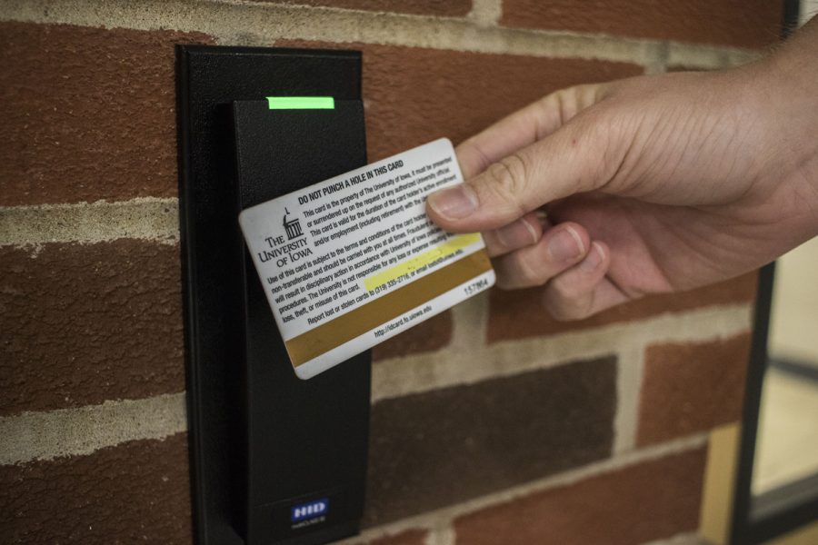 In this photo illustration, a UI ID card is seen swiping into a door. 