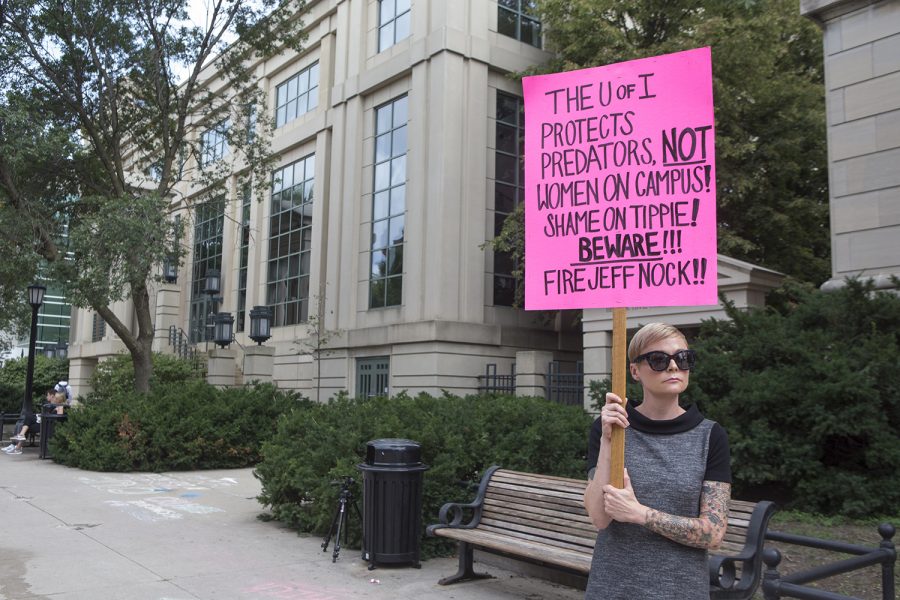 Liana Reimer, protest organizer and employee at the UI Hospital, stands with her sign during the Jeffery Nock Protest outside of the Pappajohn Business Building on Aug. 30, 2018. Students and faculty turned out to protest Professor Jeffery B. Nocks, who is still employed at the university despite charges of taking photographs of women at the Campus Recreation and Wellness Center.