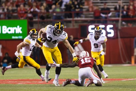 Iowa linebacker Kristian Welch avoids Nebraska wide receiver DeMornay Pierson-El after intercepting a deflected pass during the Iowa/Nebraska football game in Memorial Stadium on Friday, Nov. 24, 2017. The Hawkeyes defeated the Cornhuskers, 56-14. 