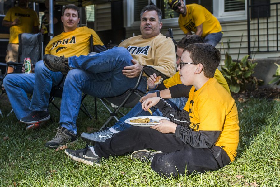 A young fans eats food with his family while tailgating on Saturday, September 22, 2018. Both Hawkeye and Badger fans tailgated throughout Iowa City prior to the Iowa vs. Wisconsin  football game. (Katina Zentz/The Daily Iowan)