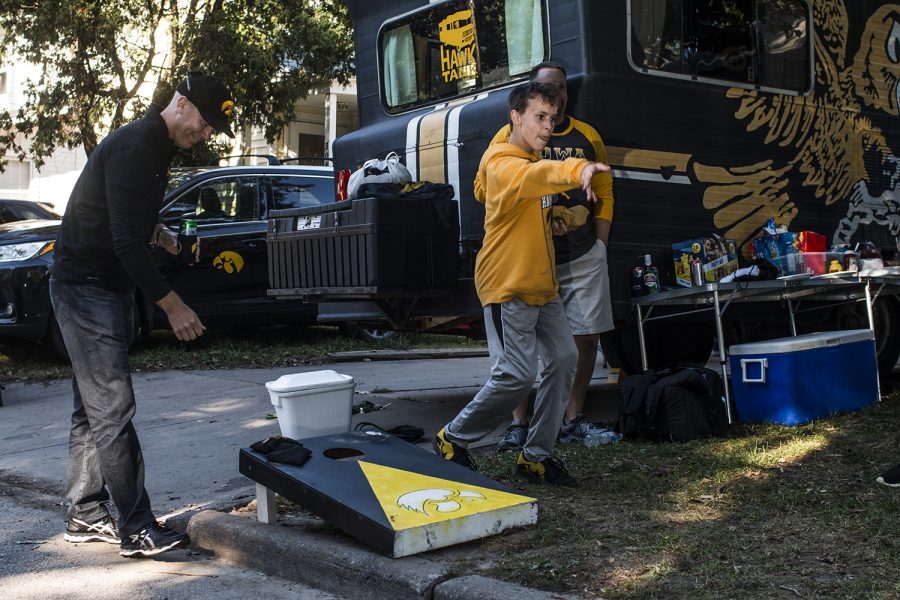 A young fan plays a beanbag game with his family on Saturday, September 22, 2018. Both Hawkeye and Badger fans tailgated throughout Iowa City prior to the Iowa vs. Wisconsin  football game. (Katina Zentz/The Daily Iowan)