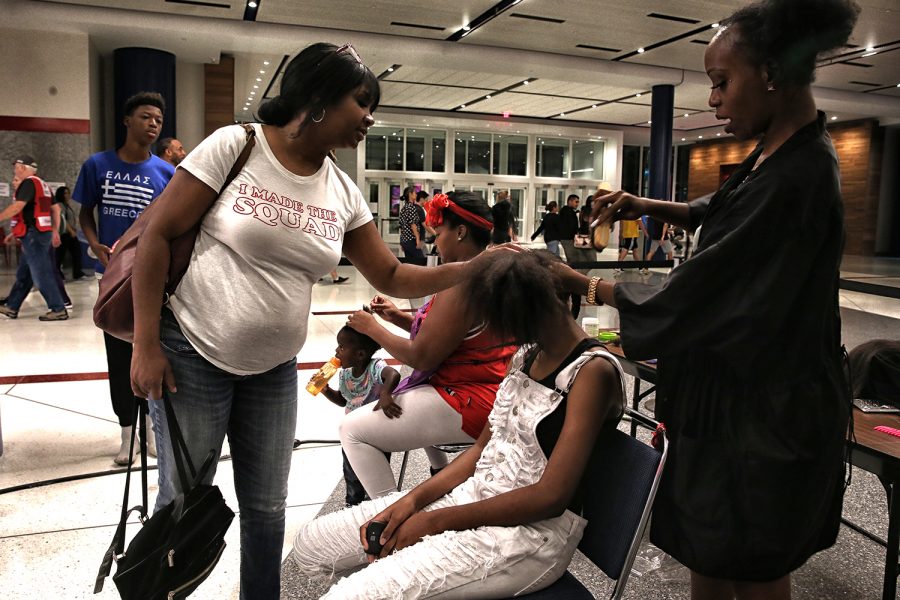 Yvonne Ferguson-Smith helps with her daughter Yasmins haircut inside the George R. Brown Convention Center on Aug. 31, 2017. Meka Fisher, of Laced Up By Meka hair salon, volunteered with nearly a dozen other barbers and hairdressers to at the main Hurricane Harvey evacuation center. (Robert Gauthier/Los Angeles Times/TNS)