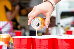 A tailgater pours out a beer for beer pong in Iowa City on Saturday, Sept. 1, 2018. 