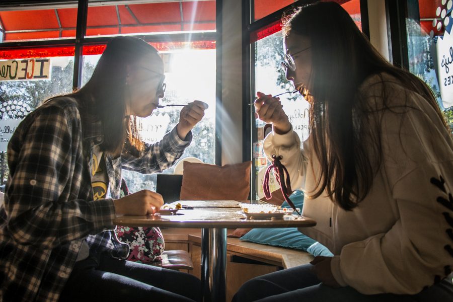 UI students Yujing Lu (left) and Vicky Wang (right) take a bite of their cupcakes at Molly's Cupcakes on Monday, Sept. 10, 2018. "The cupcakes here are amazing," Lu said.