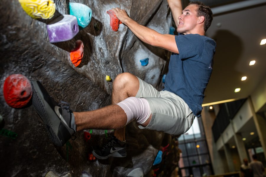 Universtiy of Iowa student Chase Thurman climbs the rock wall in the CRWC on Wednesday, Sept. 5, 2018. Chase suffered a severe knee injury in a car accident but has continued rehab on his knee and exercises rigorously.