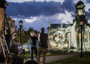 Crew members take photos of the art projected onto the Old Capitol on Wednesday, October 3, 2018. International light artist Gerry Hofstetter chose the building as a backdrop to feature artwork included in his “Light Art Grand Tour USA.” 