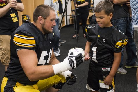 Offensive lineman Ross Reynolds (left) signs a football for Kid Captain Ean Gorsh (right) during Iowa Football Kids Day at Kinnick Stadium on Saturday, August 11, 2018. The 2018 Kid Captains met the Iowa football team and participated in a behind-the-scenes tour of Kinnick Stadium. Each childs story will be featured throughout the 2018 Iowa football season.