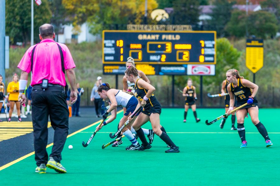 Field hockey players battle for possession as time winds down during a field hockey match between Michigan and Iowa on Friday, Oct. 5, 2018. 