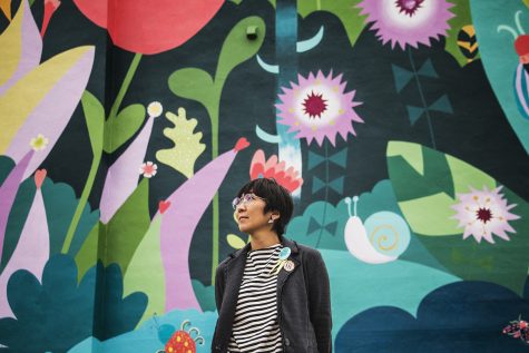 Artist Sayuri Sasaki Hemann stands in front of the Coexist mural on Washington Street on Tuesday, Oct. 2, 2018. Hemann directed young artists from the United Action for Youth to help create this work of art.