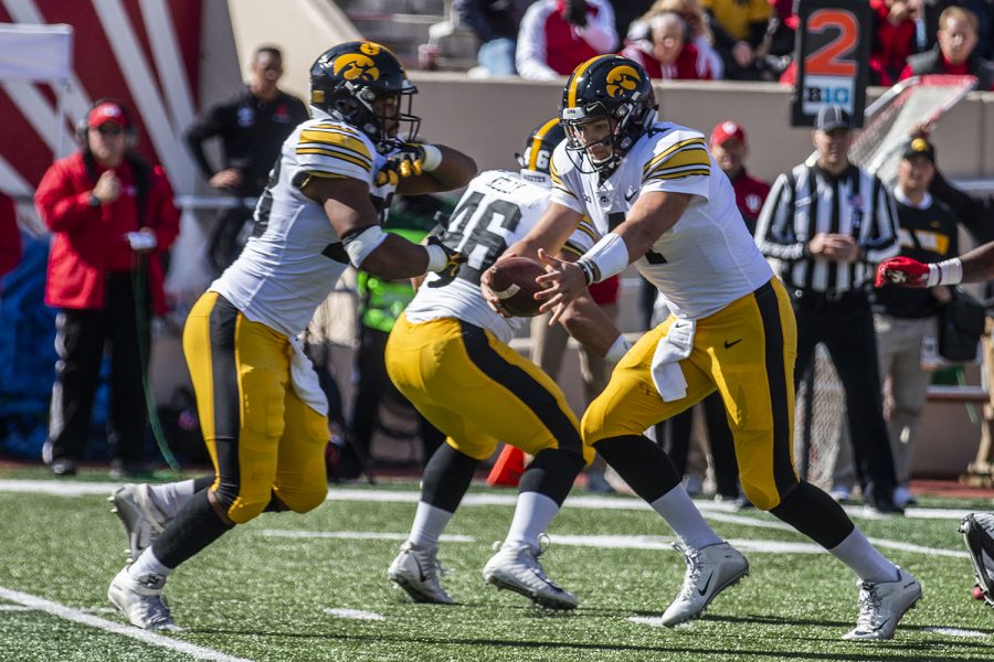 Iowa quarterback Nate Stanley hands the ball off to Iowa running back Toren Young during Iowa's game at Indiana at Memorial Stadium in Bloomington on Saturday, October 13, 2018. The Hawkeyes beat the Hoosiers 42-16.