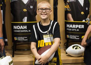 Kid Captain Noah Hodgins stands in front of his banner during Iowa Football Kids Day at Kinnick on Aug. 11.