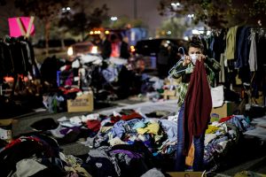 Jessica Sijan, whose family is from Paradise and lost everything to the Camp Fire, volunteers to sort out clothes for evacuees gathered at a Walmart parking lot in Chico, Calif., on Tuesday, Nov. 13, 2018. (Marcus Yam/Los Angeles Times/TNS)