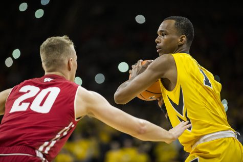 Iowa guard Maishe Dailey (1) looks for an open pass around Wisconsins T.J. Schlundt (20) during the NCAA mens basketball game between Iowa and Wisconsin at Carver-Hawkeye Arena on Tuesday, Jan. 23, 2018. The Hawkeyes are going into the game with a conference record of 1-7. Iowa went on to defeat Wisconsin 85-67. 