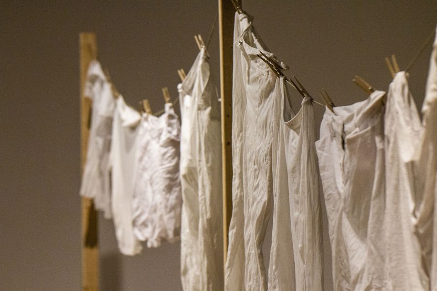 Clothes hang in the live performance piece, "Sacra Mundanam" by UI intermedia graduate student, Melissa Airy, in Art Building West on Thursday, November 29, 2018. Airy dedicates her artwork to show how the Camino de Santiago, a 500-mile pilgrimage across Spain, impacted her life personally and as an artist. In "Sacra Mundanam," Airy shows how regular activities hold a sacredness on the pilgrimage.