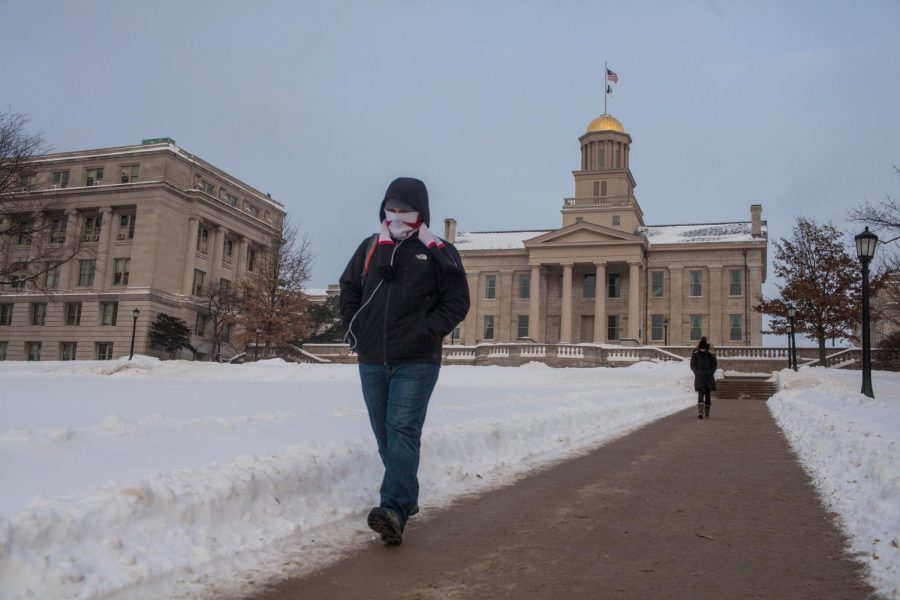 UI freshman Thomas Schutter walks in front of the Old Capitol on Monday. 