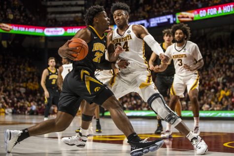 Iowa center Tyler Cook (25) dribbles past Minnesota forward Eric Curry (24) during the mens basketball game vs. Minnesota at Williams Arena on Sunday, January 27, 2019. 