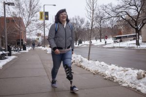 UI senior Erica Cole walks on campus on Tuesday, January 15, 2019. Cole started a business called No Limbits which creates colorful covers for amputees prosthetics. Cole says that the covers have shifted the conversations she experiences about her prosthetic.