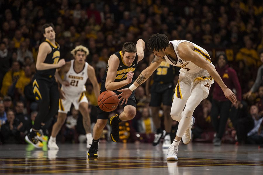 From left: Iowa forward Nicholas Baer and Minnesota guard Amir Coffey run for the ball during men's basketball vs. Minnesota at Williams Arena on Sunday, January 27, 2019. The Gophers defeated the Hawkeyes 92-87.