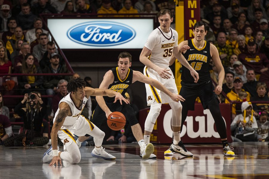 Iowa guard Connor McCaffery (30) fights for the ball against Minnesota guard Amir Coffey (5) during men's basketball vs. Minnesota at Williams Arena on Sunday, January 27, 2019. The Gophers defeated the Hawkeyes 92-87.