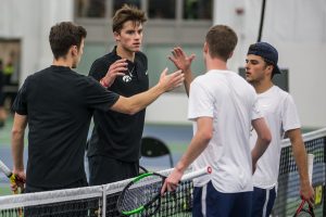 Players shake hands following a doubles set during a mens tennis match between Iowa and Marquette on Saturday, January 19, 2019. The Hawkeyes swept the Golden Eagles, 7-0.