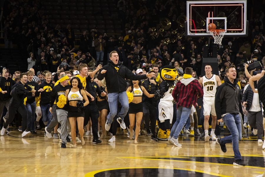 Fans storm the court and celebrate with the team during the Iowa/Michigan mens basketball game at Carver-Hawkeye Arena on Friday, February 1, 2019. The Hawkeyes took down the No. 5 ranked Wolverines, 74-59. (Lily Smith/The Daily Iowan)