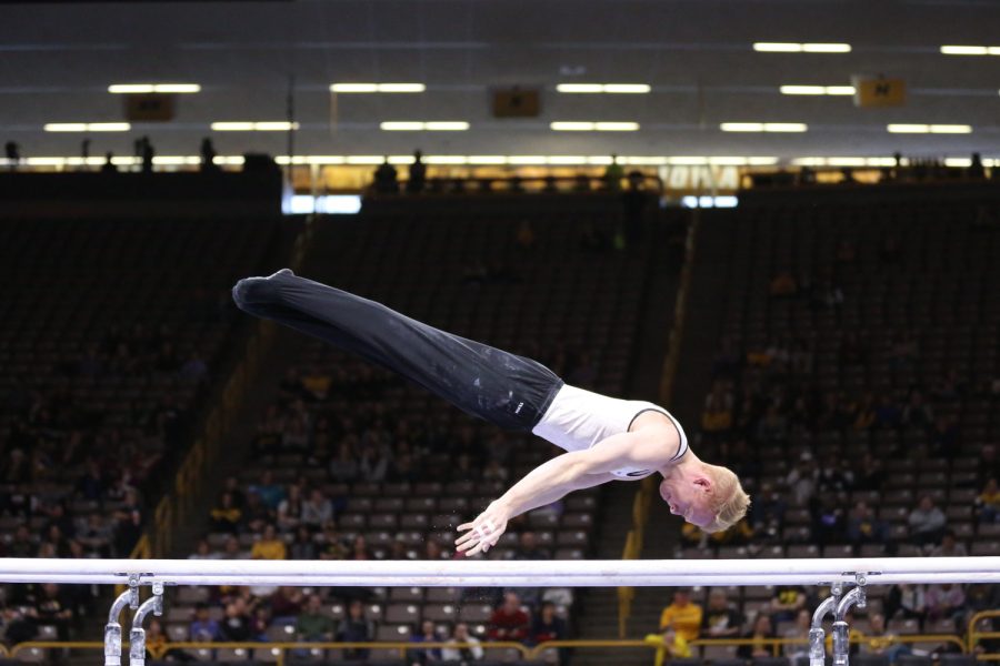 Iowa gymnast Nick Merryman performs on the parallel bars during a gymnastics meet against Minnesota and Illinois-Chicago on Saturday, Feb 2, 2019. The Golden Gophers won the meet with a total score of 406.400 with the Hawkeyes scoring 401.600 and the Flames scoring 355.750.