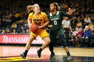 Iowa guard Kathleen Doyle (22) fights through a defender during a basketball game against Michigan State on Thursday, Feb. 7, 2019. The Hawkeyes defeated the Spartans 86-71. 