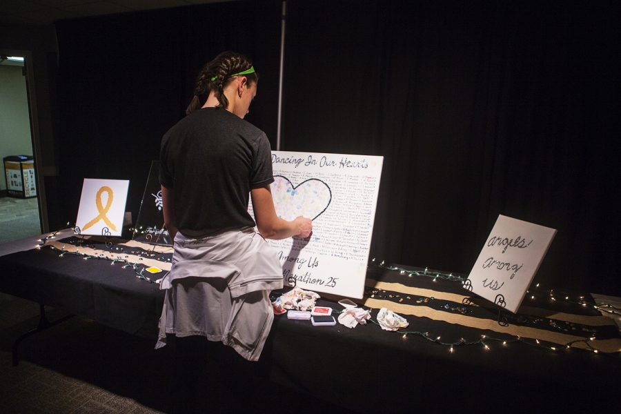 A dancer prints her thumbprint on the Dancing in Our Hearts memorial during Dance Marathon 25 at the Iowa Memorial Union on Saturday, February 2, 2019. The room is dedicated to kids who lost their lives to childhood cancer. 