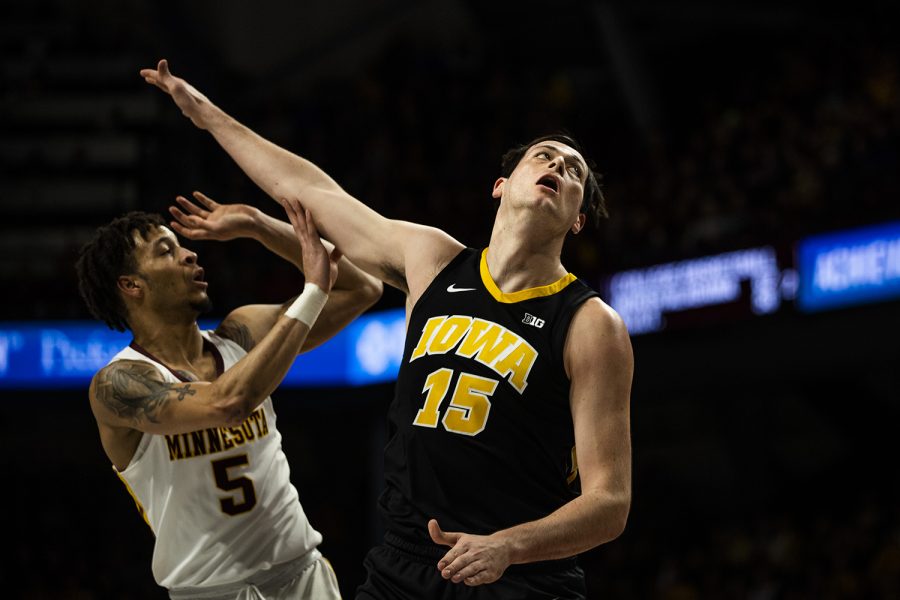 Iowa forward Ryan Kriener watches as Minnesota guard Amir Coffey shoots the ball during the men's basketball game vs. Minnesota at Williams Arena on Sunday, January 27, 2019. 