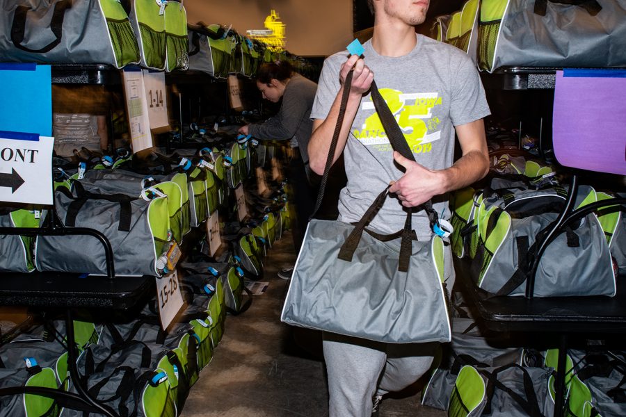 A volunteer retrieves a bag from the bag check during Dance Marathon 25 on Friday, Feb. 1, 2019.