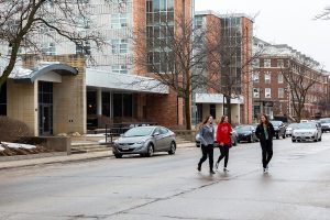 Pedestrians jaywalk across Clinton St. in front of Burge residence hall on Sunday, Feb. 3, 2019. The lack of marked crosswalks on this street prevents pedestrians from crossing in an orderly manner.