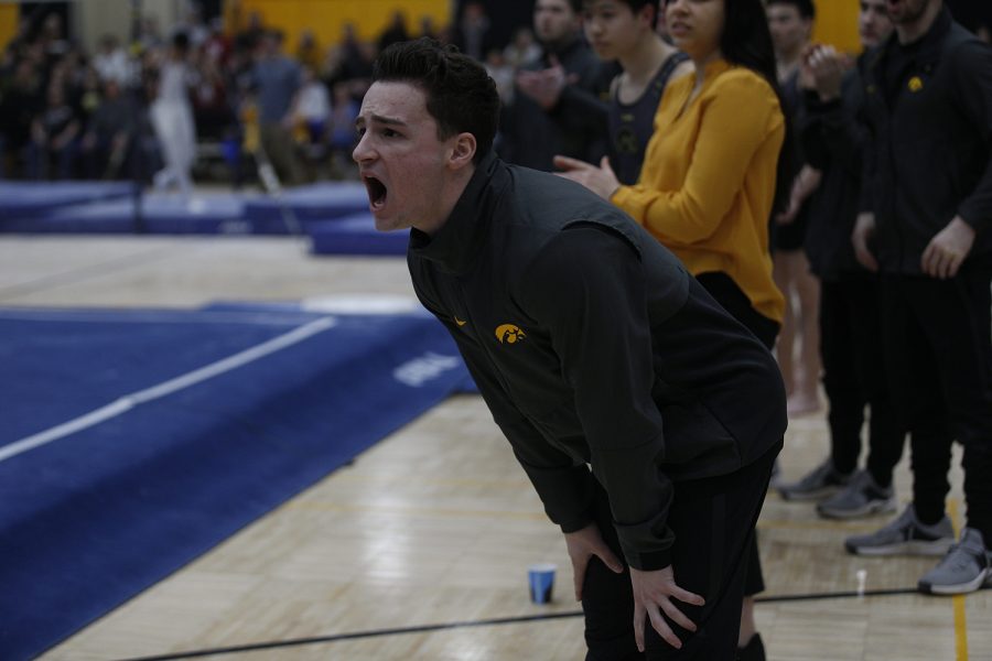 Jake Brodarzon cheers on teammate Noah Scigliano as he performs on the floor during the meet against Nebraska at the UI Field House on Saturday, March 2, 2019. Iowa took the victory with a score of 406.500 over Nebraska with a score of 403.550.