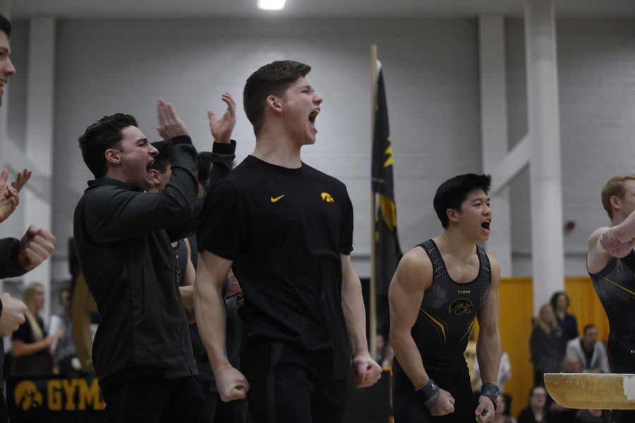 Stewart Brown celebrates as a teammate sticks a perfect landing off of the pommel horse during the meet against Nebraska at the UI Field House on Saturday, March 2, 2019. Iowa took the victory with a score of 406.500 over Nebraska with a score of 403.550.