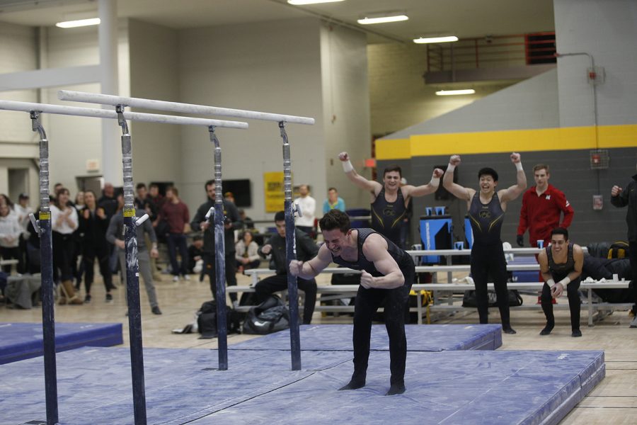 Jake Brodarzon celebrates a stuck landing after his parallel bars event during theme against Nebraska at the UI Field House on Saturday, March 2, 2019. Iowa took the victory with a score of 406.500 over Nebraska with a score of 403.550.